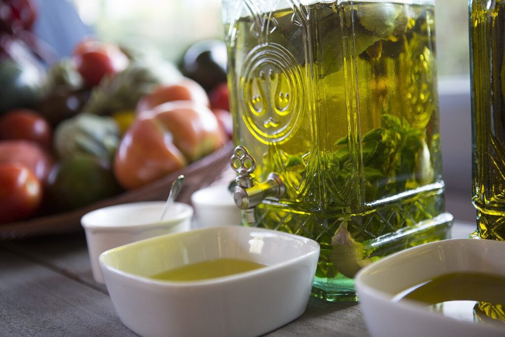 Dispensador de aceite de oliva con hierbas aromáticas y tomates en La Quinta de Illescas