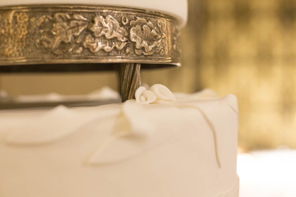 Detalle de la base metálica con relieves de hojas de una tarta de bodas en la Quinta de Illescas