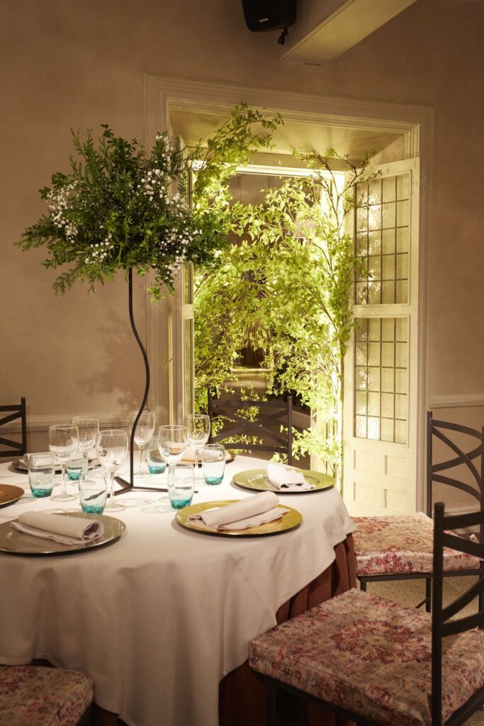 Decoración de mesa con centros florales elevados y sillas de forja en la Quinta de Illescas