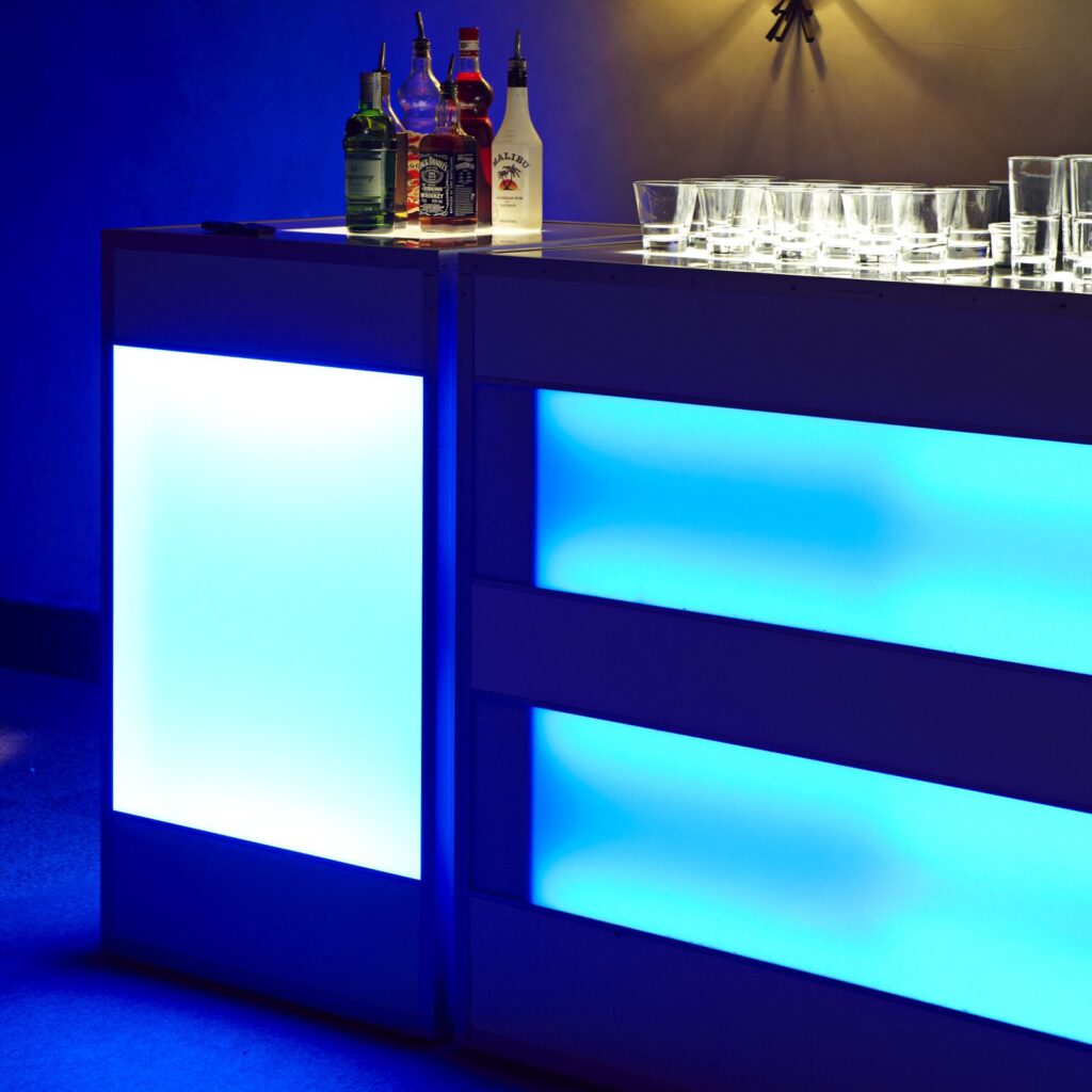 Barra de bar iluminada con luces LED azules y botellas de licor en la Quinta de Illescas