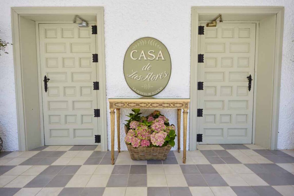 Entrada de la Casa de las Flores con mesa y flores.