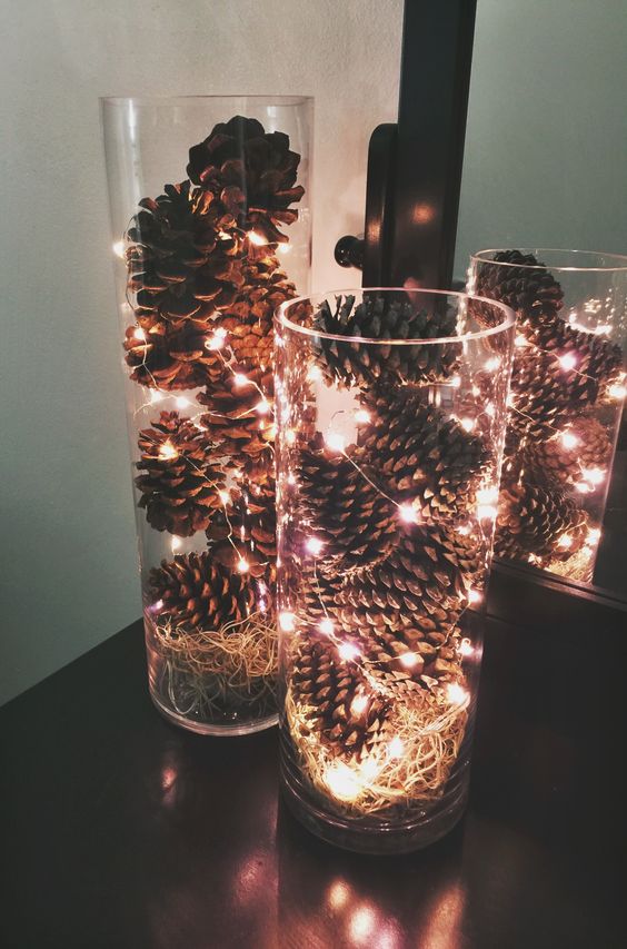 Jarrones de cristal decorados con piñas y luces