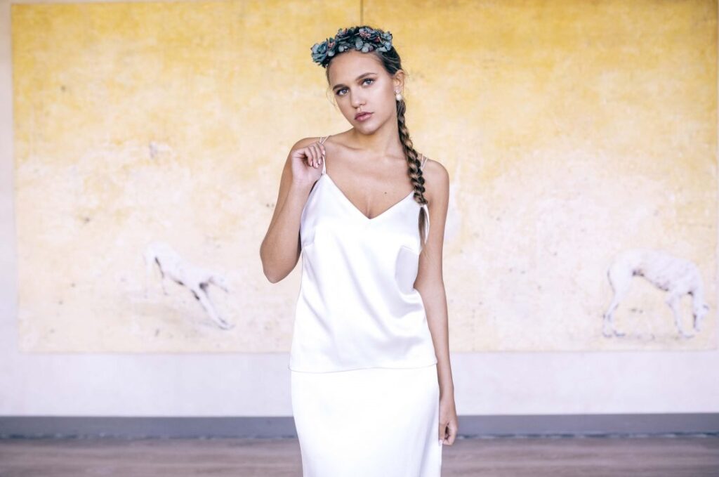 Modelo con vestido blanco satinado y corona de flores posando en La Quinta de Illescas.