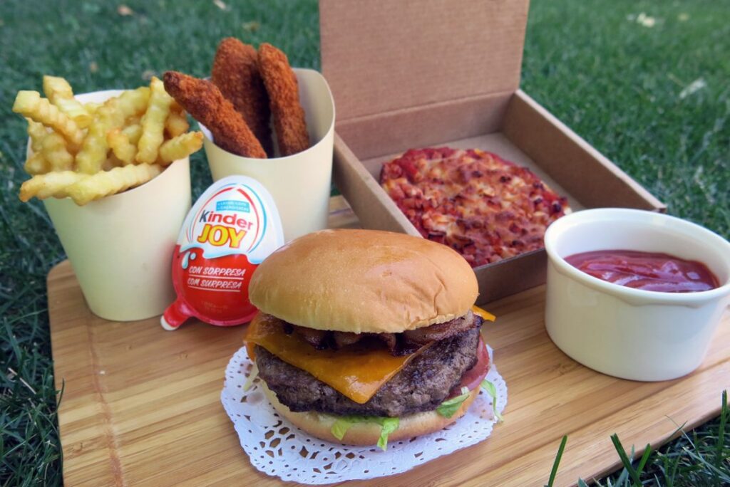 Menú infantil con patatas y fingers de pollo, hamburguesa y pizza.