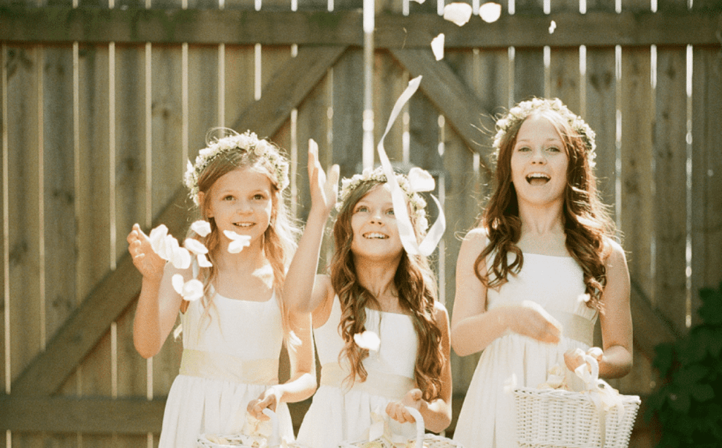 Niñas lanzando pétalos de flores en una boda.