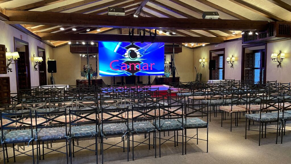 Sala de conferencias con pantallas y sillas preparadas en la Quinta de Illescas.