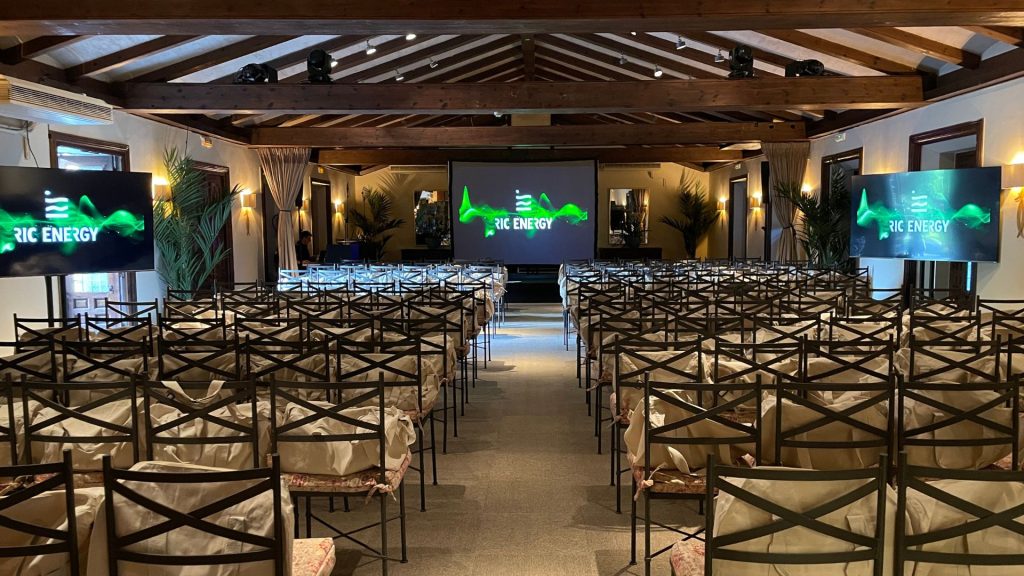 Salón de conferencias en La Quinta de Illescas montado para evento corporativo de RIC Energy con pantallas y escenario