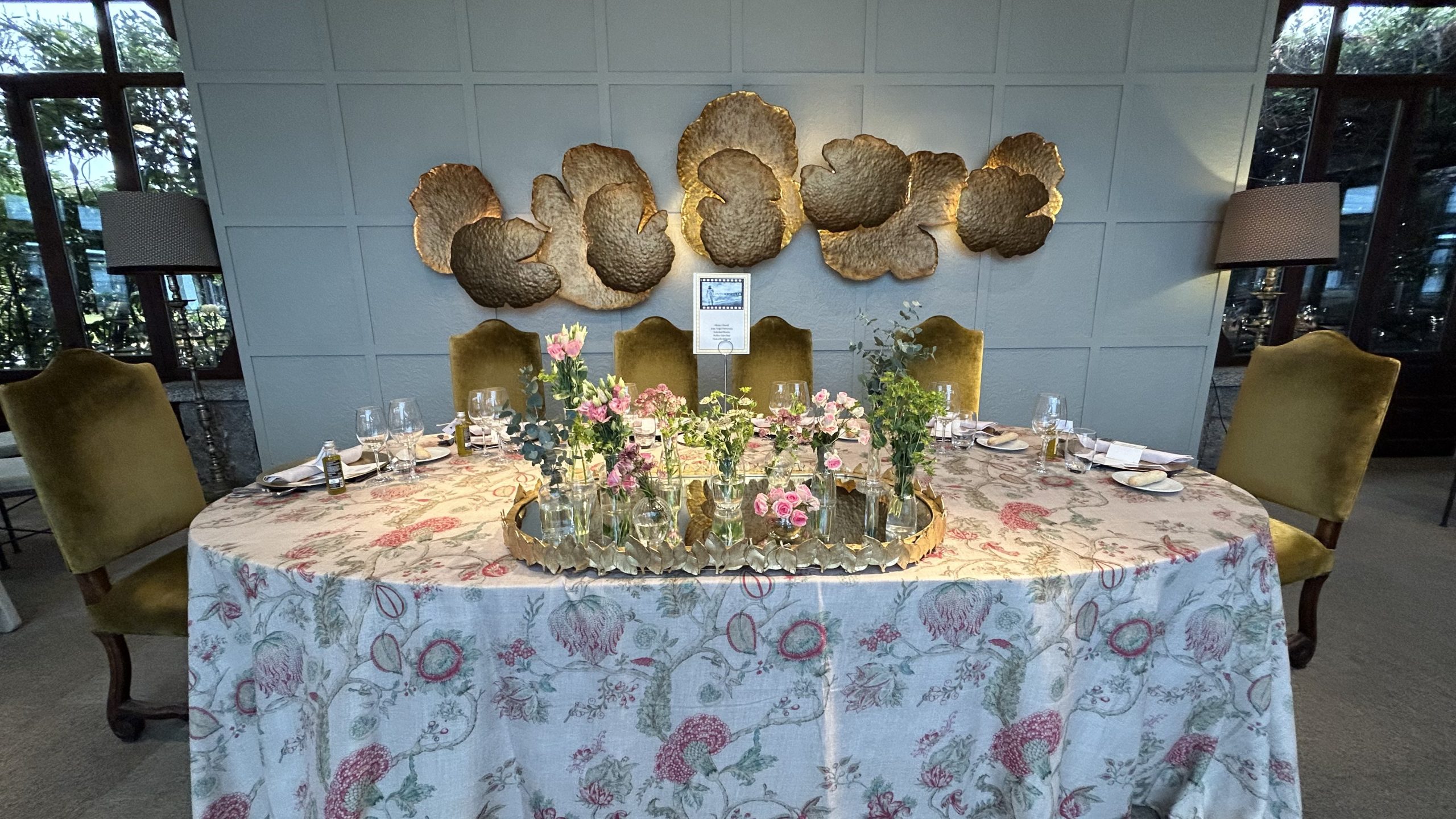 Mesa presidencial de boda decorada con mantel floral y centros de flores rosas en La Quinta de Illescas