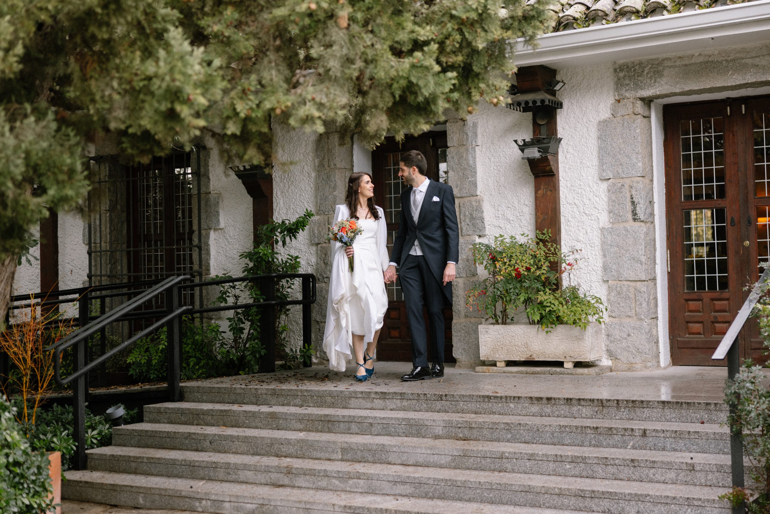 Pareja de recién casados bajando las escaleras de piedra de la entrada principal en La Quinta de Illescas.