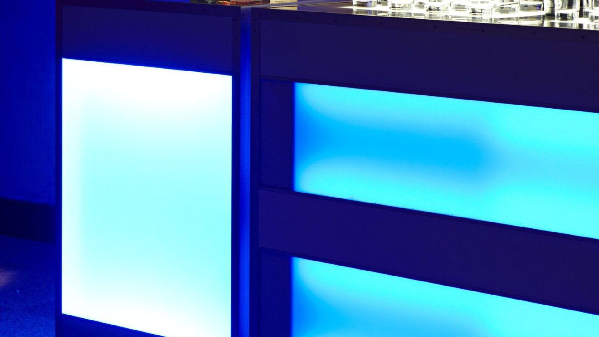 Barra de bar iluminada con luces LED azules y botellas de licor en la Quinta de Illescas