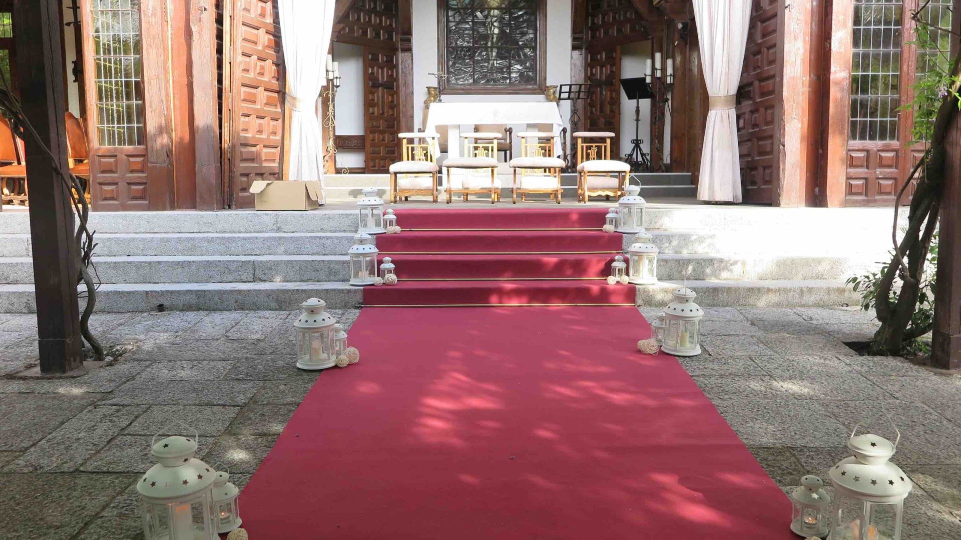 Alfombra roja decorada con faroles blancos para la entrada a la capilla